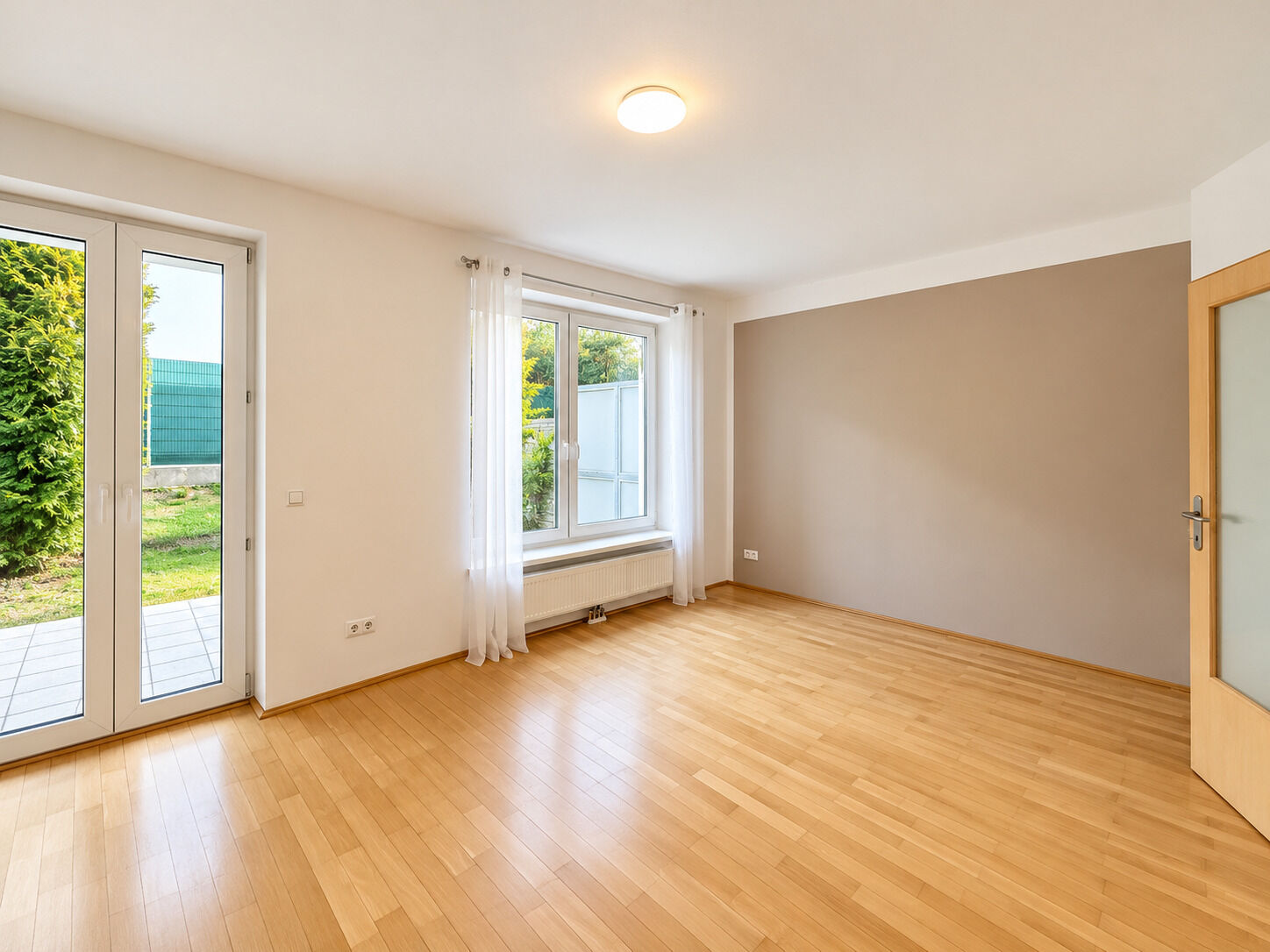 Heller moderner Wohnraum mit Gartenblick